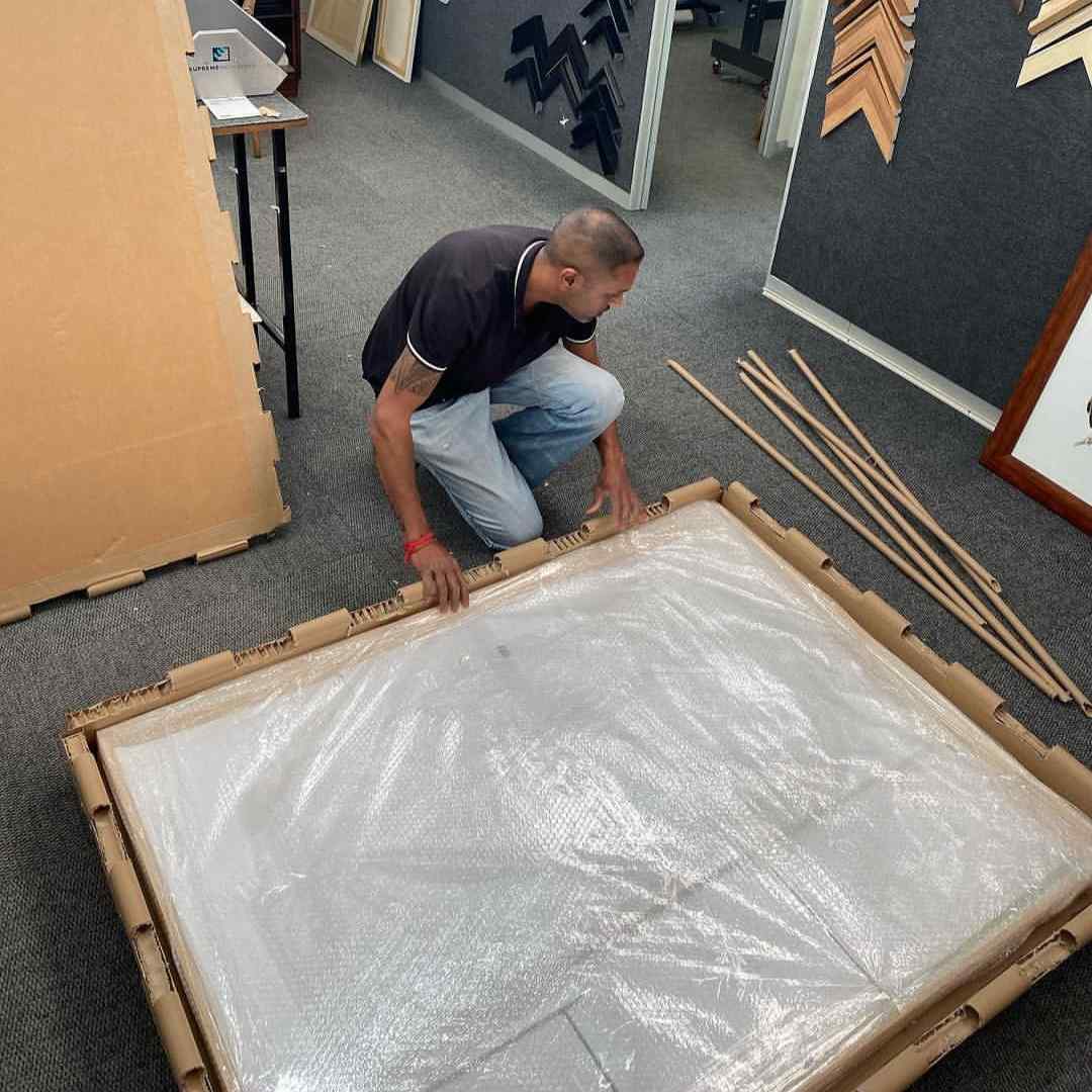 Person packing artwork in custom art packaging