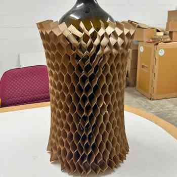 Honeycomb paper used as a wrap around a bottle for protective industrial packaging