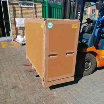 Custom furniture packaging crate with honeycomb pallet being lifted by a forklift.