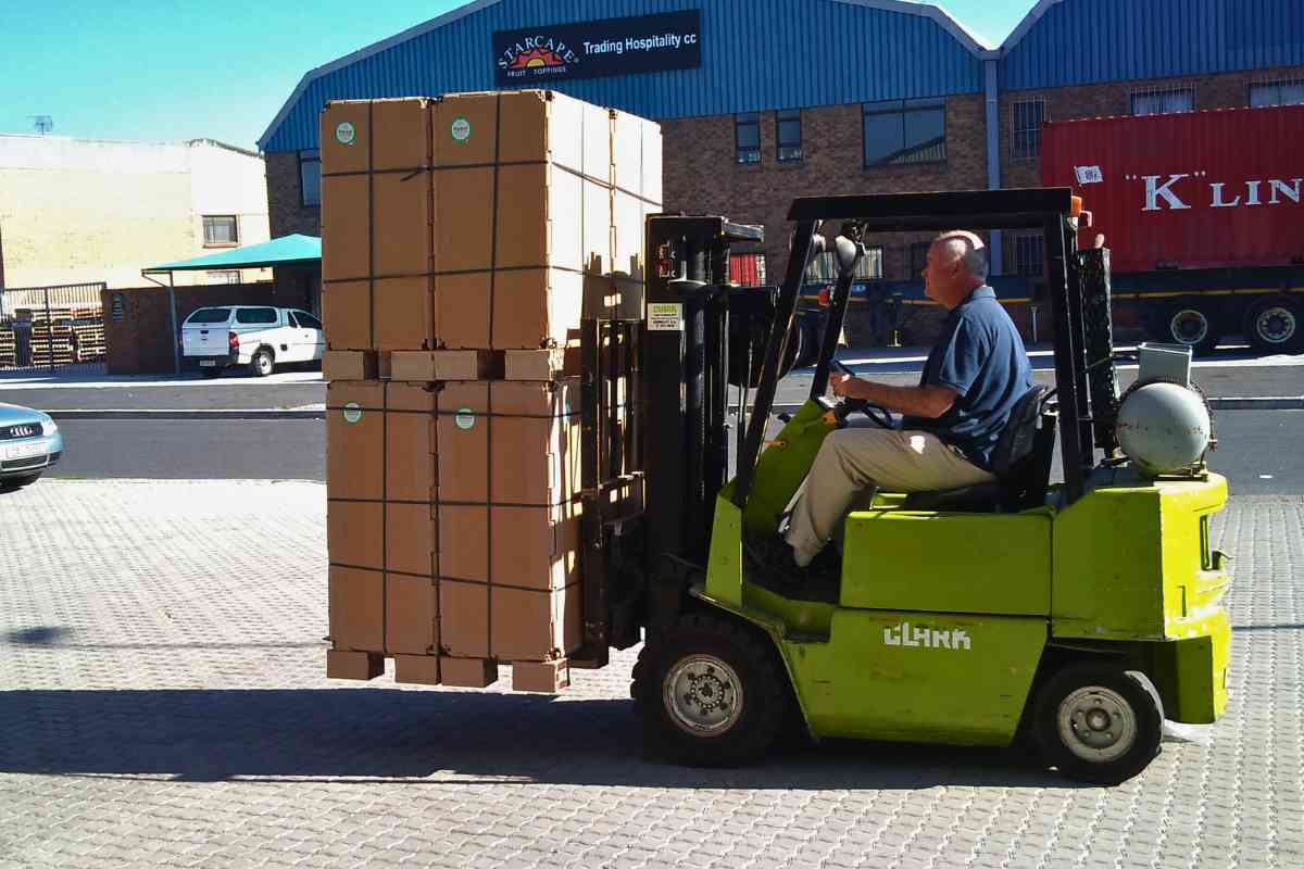 Custom-made, flat-packable Rebul freight crate pallet boxes strapped and securely loaded on a forklift for transport.