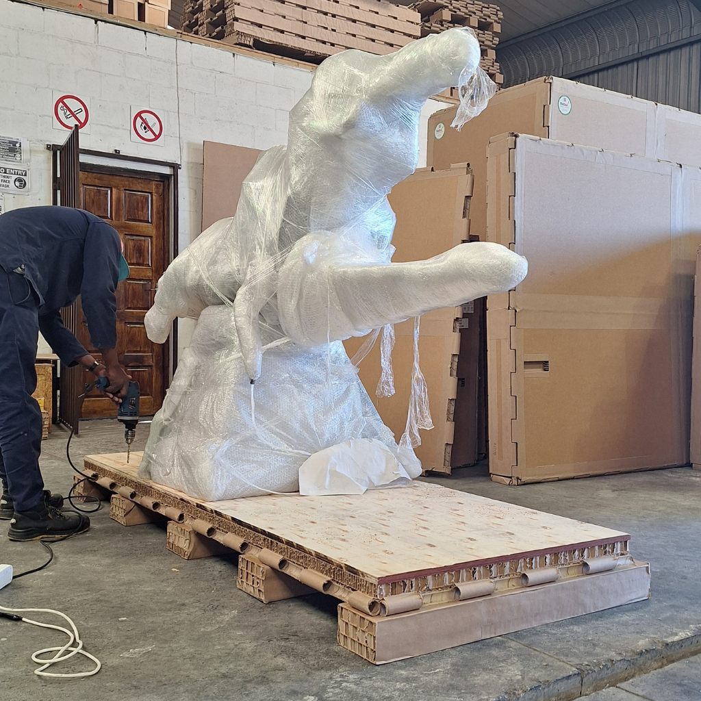 Wrapped sculpture secured on a paper pallet